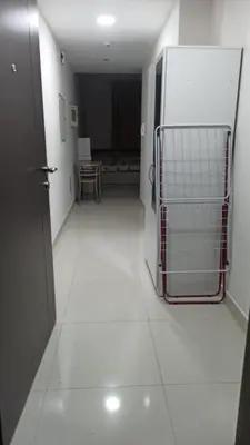 a hallway with a door and a room with a table at Furnished Studio Apartments for rent in Dubai in Dubai
