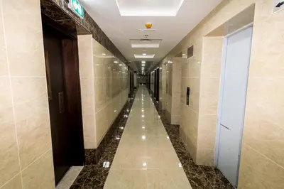 a long hallway in a building with tile walls at Furnished Studio Apartments for rent in Dubai in Dubai