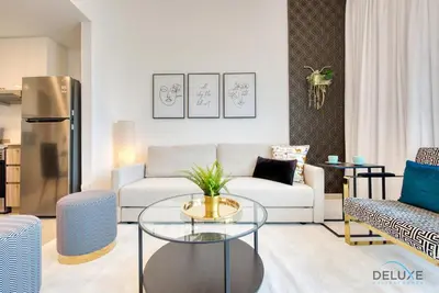 a living room with a couch and a table at Spotless 1BR at UNA Town Square Dubailand by Deluxe Holiday Homes in Dubai
