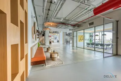an empty lobby of a store with a bench and tables at Spotless 1BR at UNA Town Square Dubailand by Deluxe Holiday Homes in Dubai