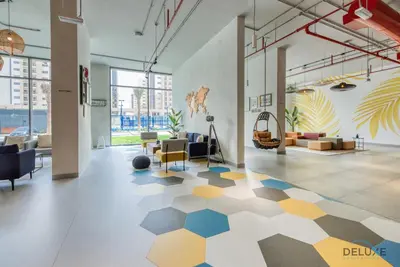 a large room with a lobby with a geometric floor at Charismatic 1BR at UNA Town Square Dubailand by Deluxe Holiday Homes in Dubai