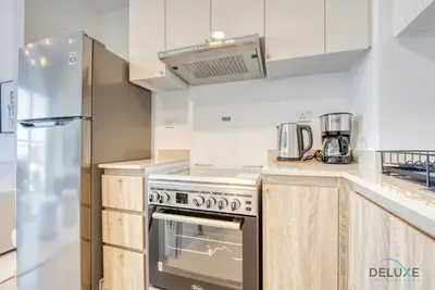 a kitchen with a stove and a refrigerator at Charismatic 1BR at UNA Town Square Dubailand by Deluxe Holiday Homes in Dubai
