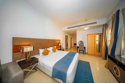 a bedroom with a large bed and a television at City Stay Grand Hotel Apartments - Al Barsha in Dubai