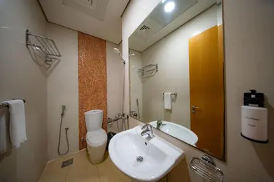a bathroom with a sink and a toilet and a mirror at City Stay Grand Hotel Apartments - Al Barsha in Dubai