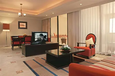 a living room with a couch and a table and a television at Arjaan by Rotana - Dubai Media City in Dubai