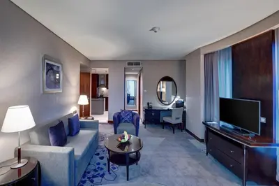 a living room with a couch and a tv at Rose Rayhaan by Rotana - Dubai in Dubai