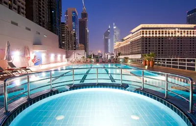 a large swimming pool on a building with a city skyline at Rose Rayhaan by Rotana - Dubai in Dubai