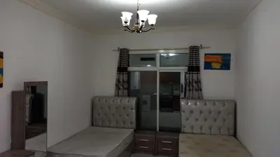 a living room with two chairs and a chandelier at Budget Rental Studio Apartments in Dubai in Dubai