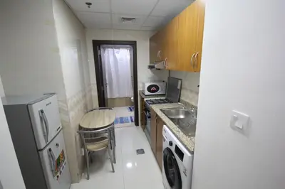 a small kitchen with a table and a refrigerator at Budget Rental Studio Apartments in Dubai in Dubai