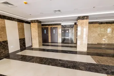 a lobby with black and white floors and columns at Budget Rental Studio Apartments in Dubai in Dubai