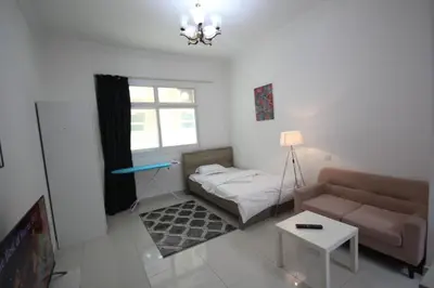 a small living room with a bed and a couch at Budget Rental Studio Apartments in Dubai in Dubai