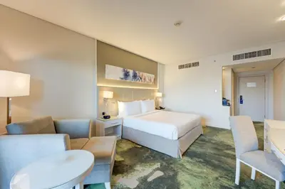 a hotel room with a bed and a table and chairs at Millennium Lakeview Hotel in Dubai