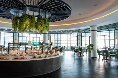 a restaurant with a buffet line with tables and chairs at Millennium Lakeview Hotel in Dubai