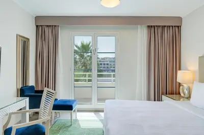 a hotel room with a bed and a balcony at Millennium Lakeview Hotel in Dubai