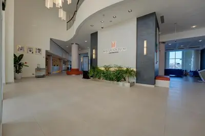 an empty lobby of a building with plants at Millennium Lakeview Hotel in Dubai