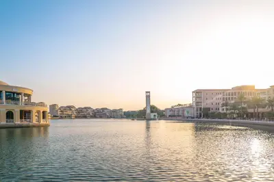 a view of a river with buildings and a clock tower at Millennium Lakeview Residences in Dubai