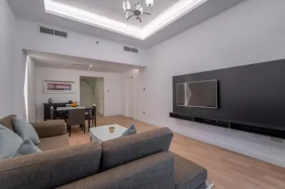 a living room with a couch and a flat screen tv at Rose Garden Hotel Apartments - Al Barsha, Near Metro Station in Dubai