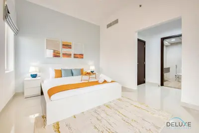 a white bedroom with a bed and a rug at Sunny 1BR at Canal Residences West Dubai Sports City by Deluxe Holiday Homes in Dubai