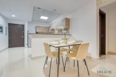 a dining room with a table and chairs at Sunny 1BR at Canal Residences West Dubai Sports City by Deluxe Holiday Homes in Dubai