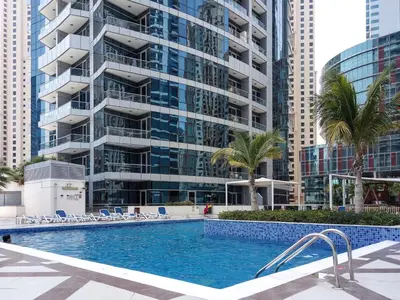 a swimming pool in front of a tall building at The Smart Concierge - Bay Central in Dubai