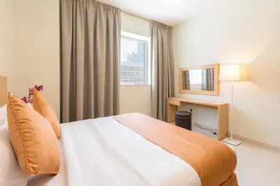 a hotel room with a bed and a window at Grand Stay Holiday Homes Rental in Dubai