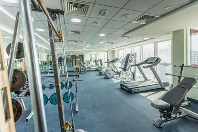 a gym with cardio equipment and treadmills at Grand Stay Holiday Homes Rental in Dubai