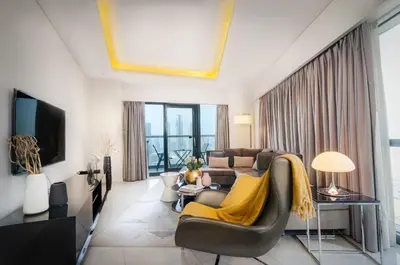 a living room with a couch and a tv at Royal Club By RVHR, Paramount Tower B, Business Bay in Dubai