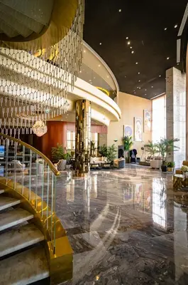 a lobby with a staircase and a large building at Royal Club By RVHR, Paramount Tower B, Business Bay in Dubai