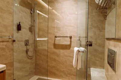 a bathroom with a shower with a glass door at HE Hotel Apartments in Dubai