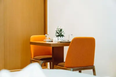 a table and two chairs with flowers on it at HE Hotel Apartments in Dubai