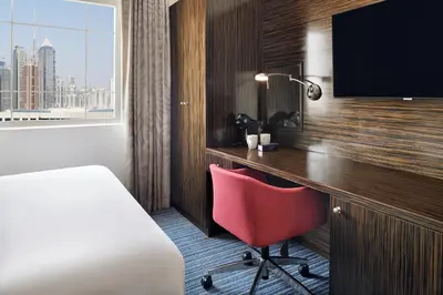 a hotel room with a desk and a red chair at Holiday Inn Express Dubai Safa Park by IHG in Dubai