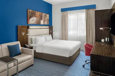 a hotel room with a bed and a chair at Holiday Inn Express Dubai Safa Park by IHG in Dubai