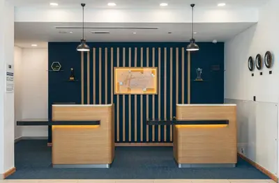 a lobby with two tables and a clock on the wall at Holiday Inn Express Dubai, Jumeirah by IHG in Dubai