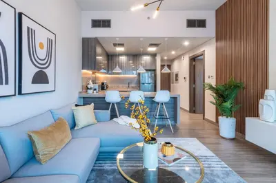 a living room with a blue couch and a table at GuestReady - Gray Cloud Retreat - MBL Cluster in Dubai