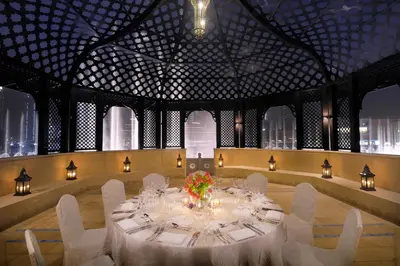 a dining room with a table and white chairs at Palace Downtown in Dubai