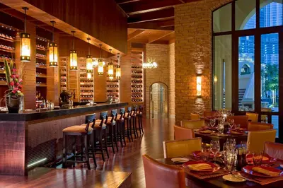 a restaurant with tables and chairs and a bar at Palace Downtown in Dubai