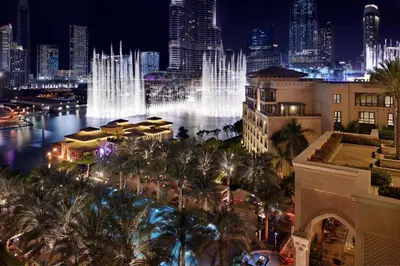 a view of a city at night with a fountain at Palace Downtown in Dubai