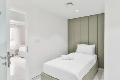 a bedroom with a white bed and a mirror at Waterfront Luxury 3BR with maids room in JBR, Dubai in Dubai