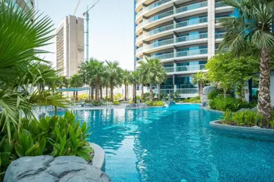 a swimming pool with palm trees and a building at Maison Privee - Cool Dubai Apt next Burj Khalifa & Design District in Dubai