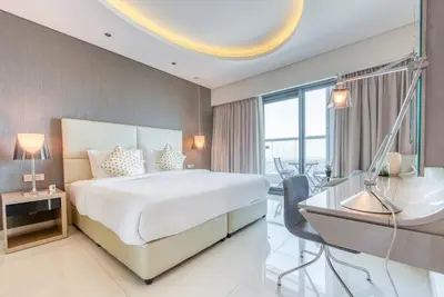 a hotel room with a bed and a desk and a desk at Maison Privee - Cool Dubai Apt next Burj Khalifa & Design District in Dubai