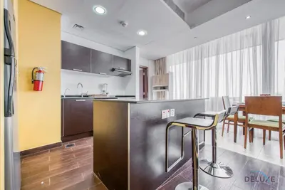 a kitchen and dining room with a table and chairs at Homely 1BR at The Matrix Dubai Sports City by Deluxe Holiday Homes in Dubai