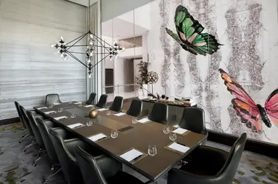 a conference room with a table and chairs and a butterfly mural at Address Downtown in Dubai