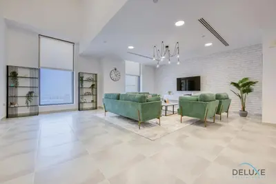 a living room with green chairs and a table at Outstanding 3BR at Sadaf 7 JBR by Deluxe Holiday Homes in Dubai
