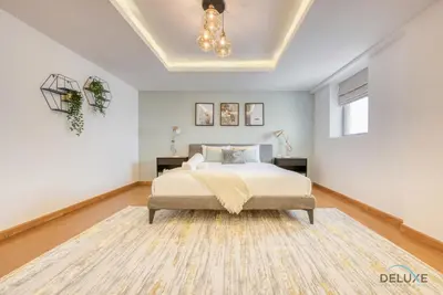 a white bedroom with a bed and a chandelier at Outstanding 3BR at Sadaf 7 JBR by Deluxe Holiday Homes in Dubai