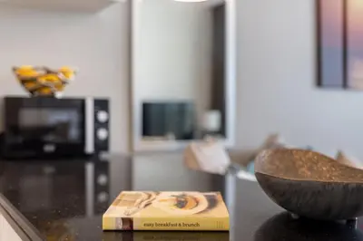 a book and a bowl on a counter in a kitchen at The Smart Concierge - Damac 108 in Dubai