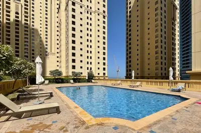 a large swimming pool in a city with tall buildings at The Smart Concierge - Bahar 6 in Dubai