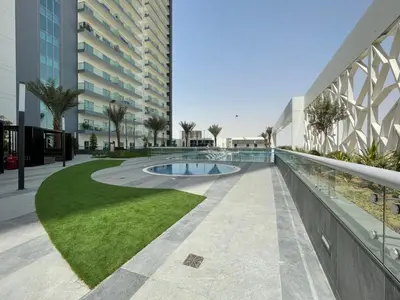 a building with a swimming pool next to a building at GuestReady Holiday Homes - A Rose in the Sky in Dubai