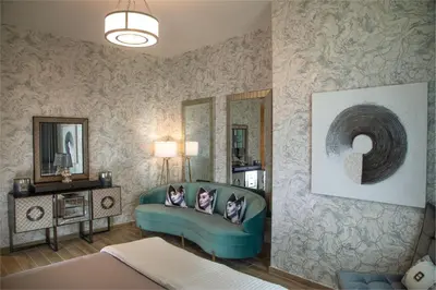 a living room with a blue couch and mirrors at Royal Club By RVHR, Noora Tower, Al Habtoor City, Business Bay in Dubai