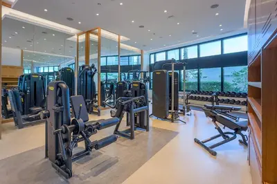 a gym with rows of tread machines and mirrors at Classy 1BR at The Address Residences in JBR by Deluxe Holiday Homes in Dubai