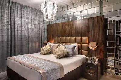 a bedroom with a large bed and a chandelier at Royal Club By RVHR, Bonnington Residential Tower - JLT in Dubai